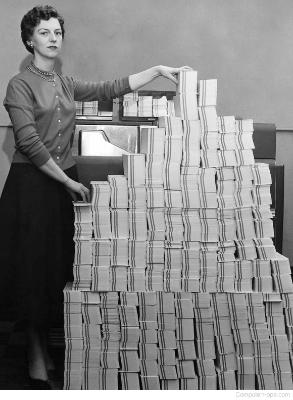 Woman standing next to thousands of punch cards